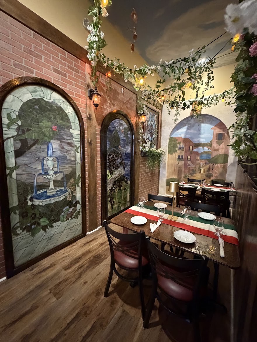 A dining corner with arched decorative panels, flowers and set tables