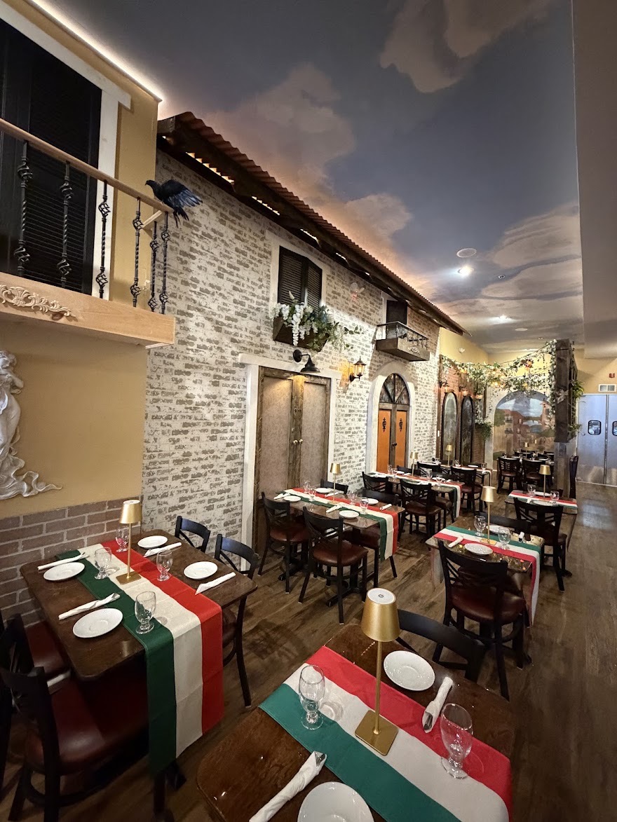 Villa Italiana’s dining room with prepared tables, Italian flag runners and a painted sky ceiling