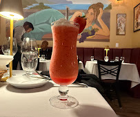 A frozen red drink served in a tall glass