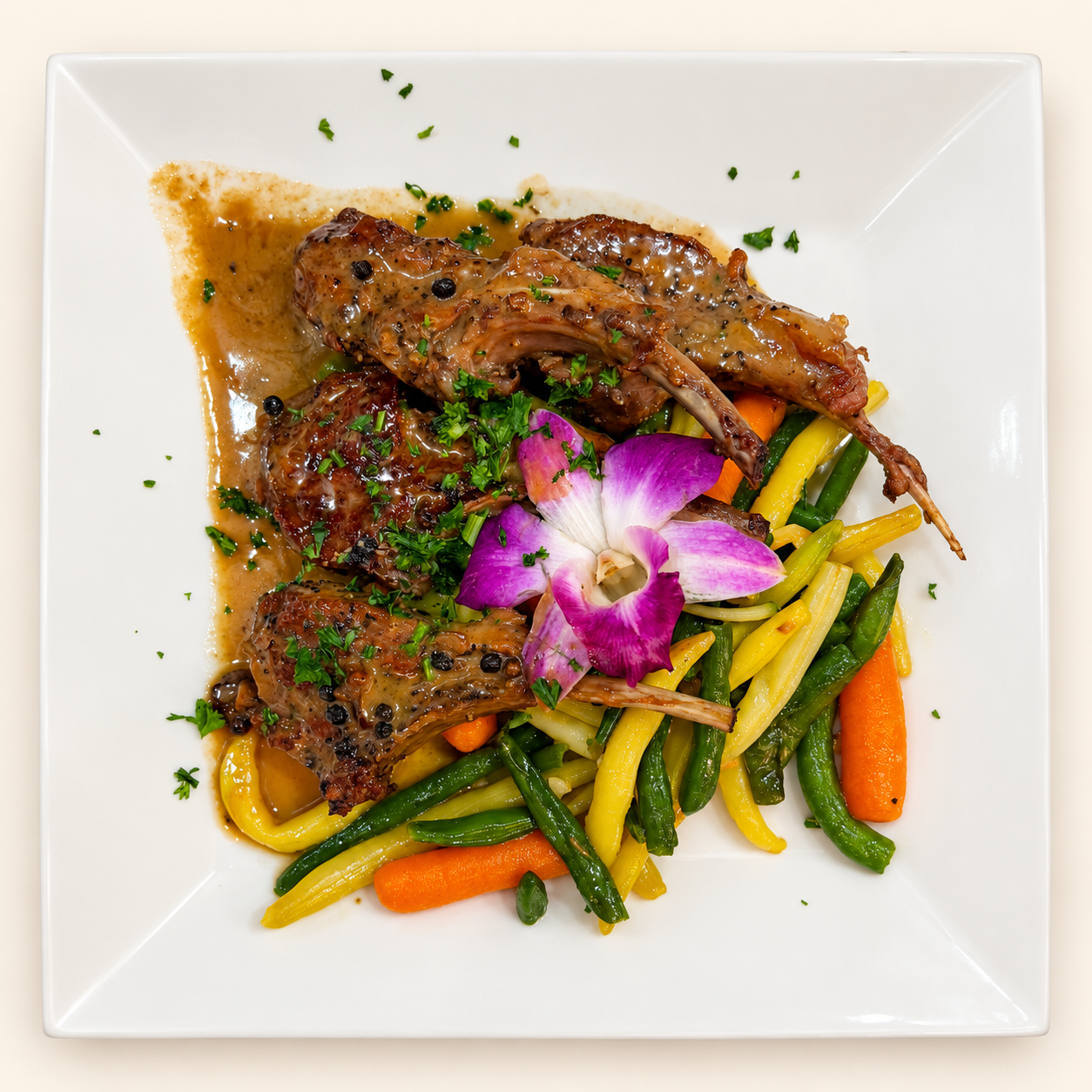 Lamb chops served with vegetables and a purple orchid garnish